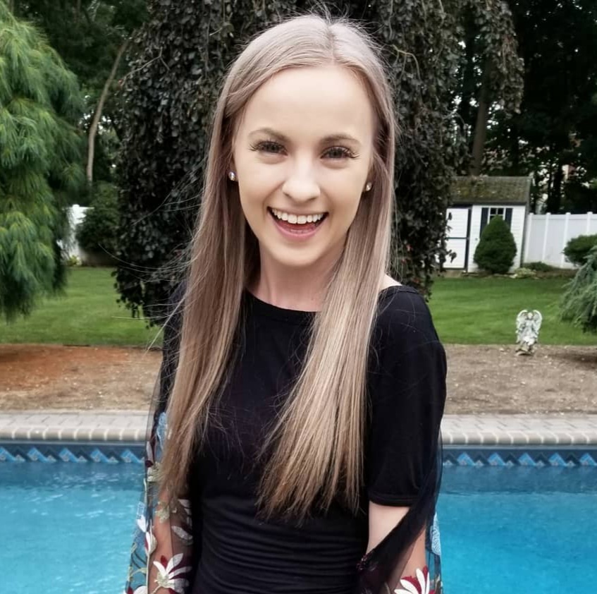 Brittany smiling in front of a pool